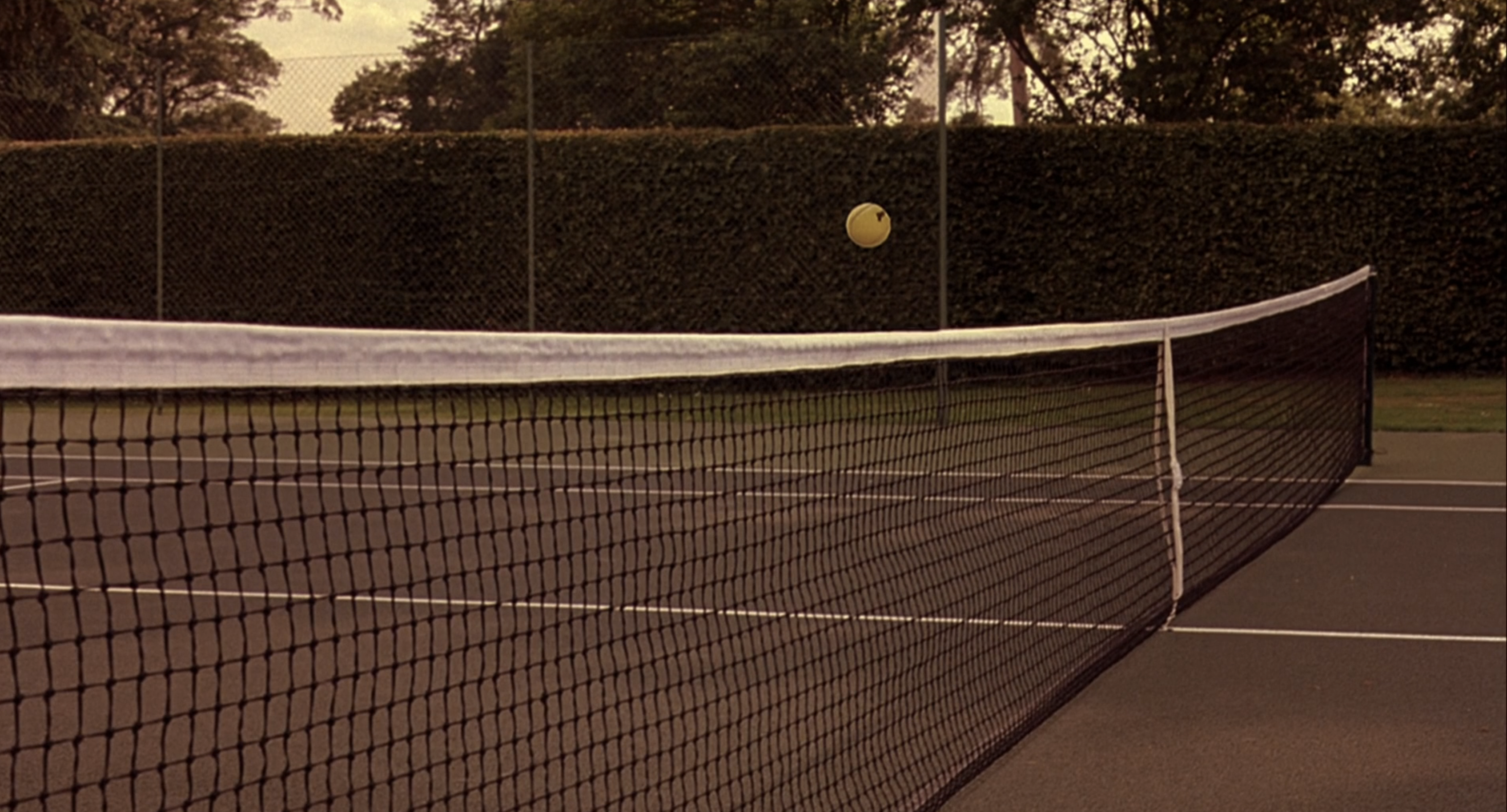 a ball hovers over the tennis net